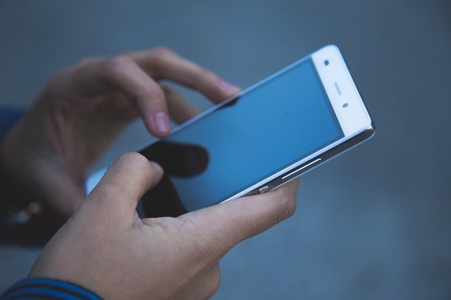 mobilní telefon v rukách muže
